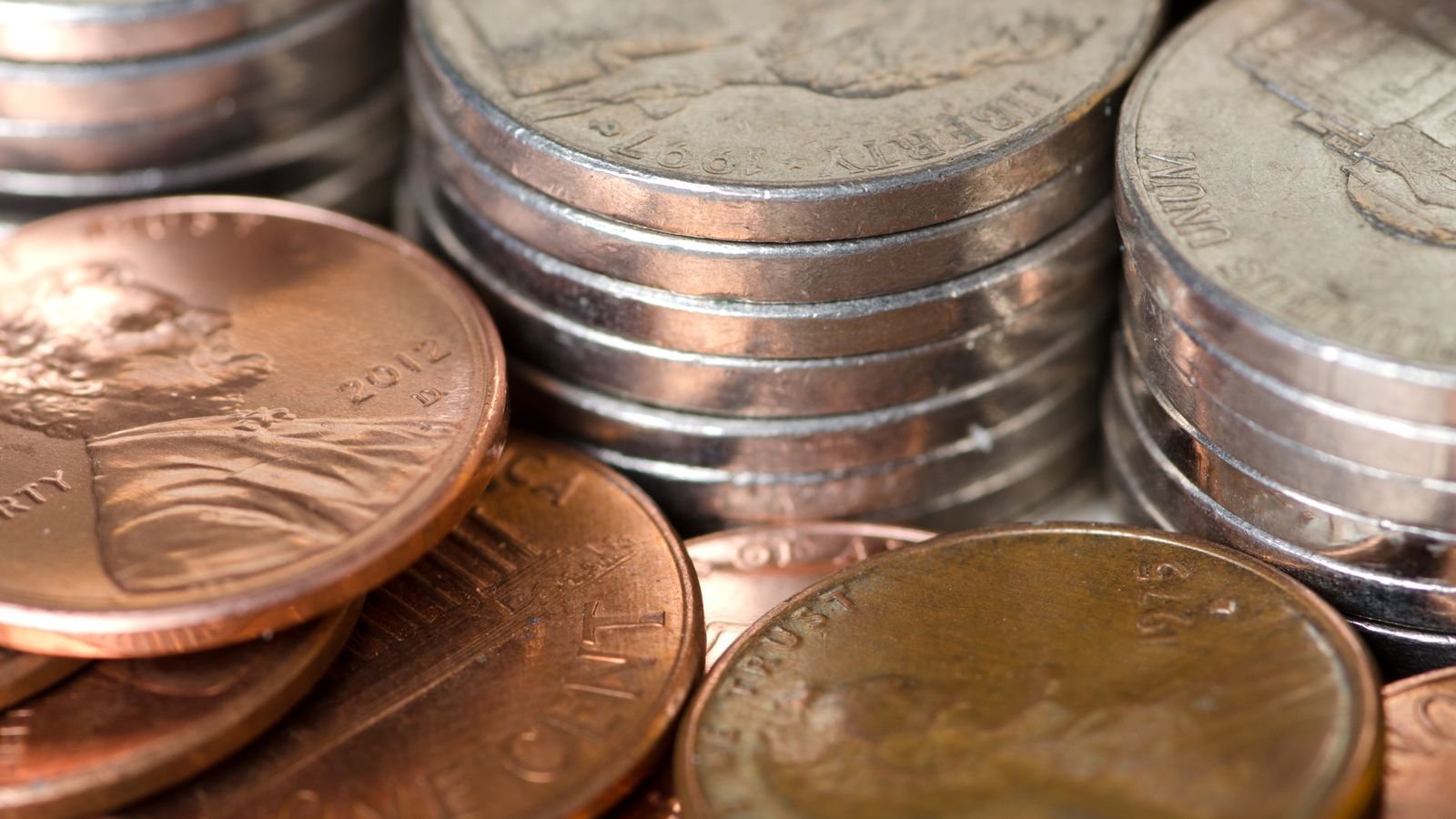 Detailed image of stacked American coins including pennies and nickels, representing retirement savings disparities across generations