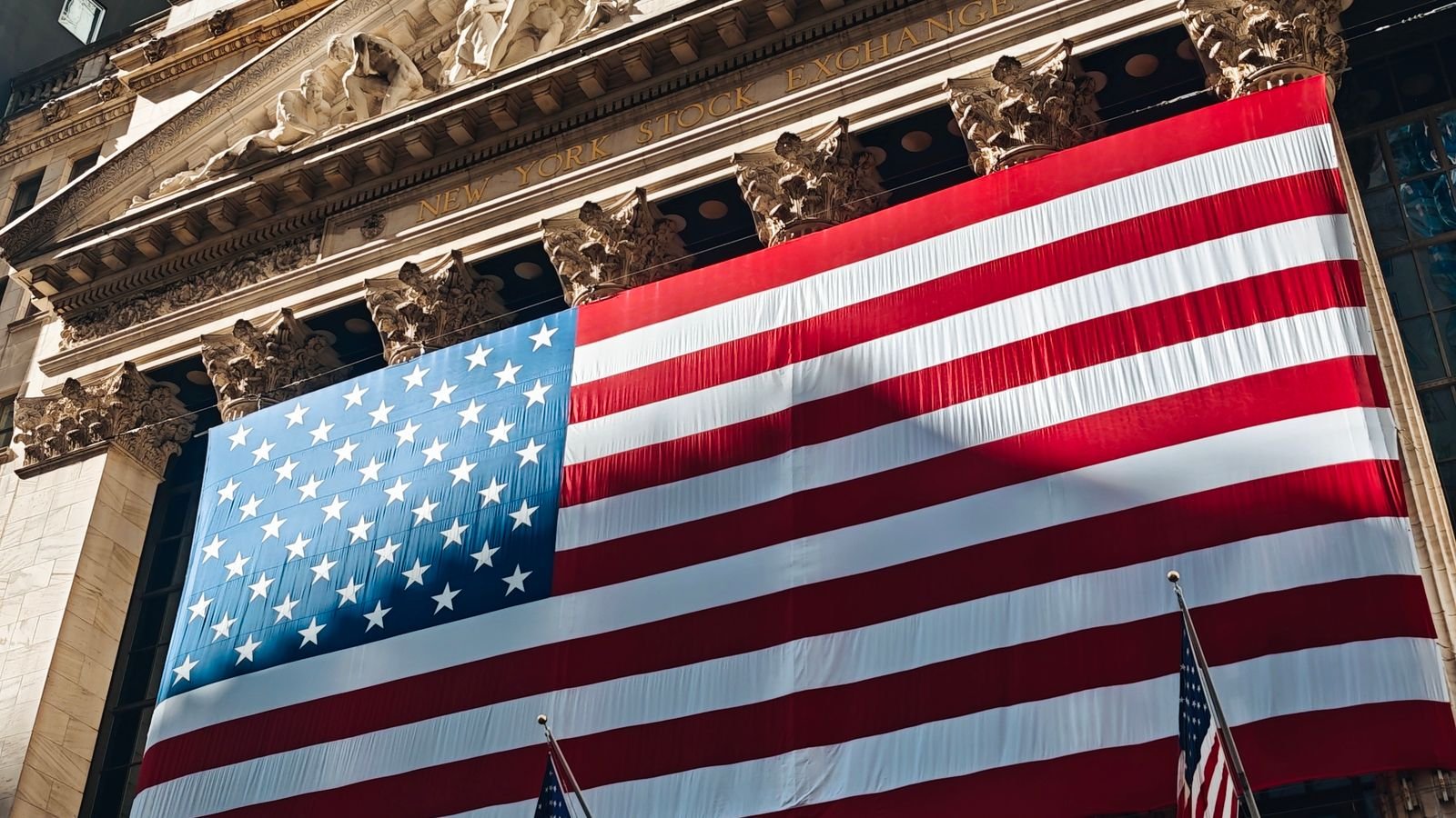 American flag on the facade of the New York Stock Exchange, representing today's stock market activity