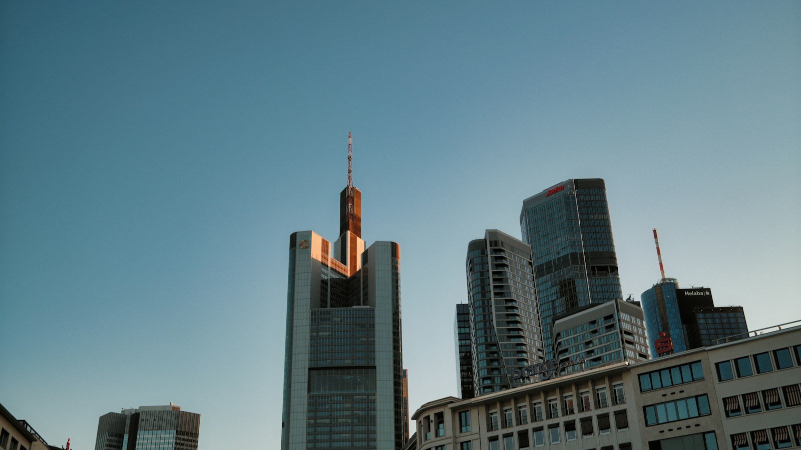 Modern glass skyscrapers rising against a clear blue sky in a financial district